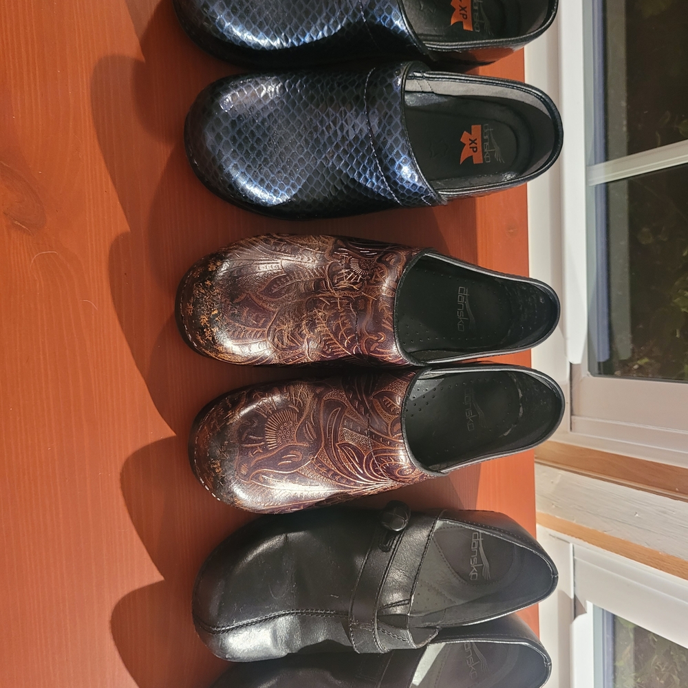 Three Pairs Of Dansko Womens Black, Blue, and Brown Shoes